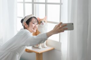 猫と写真を撮る女性